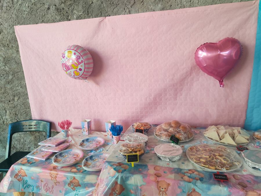 Tavolo del buffet con fondale rosa, palloncino a forma di cuore e vassoi di salatini