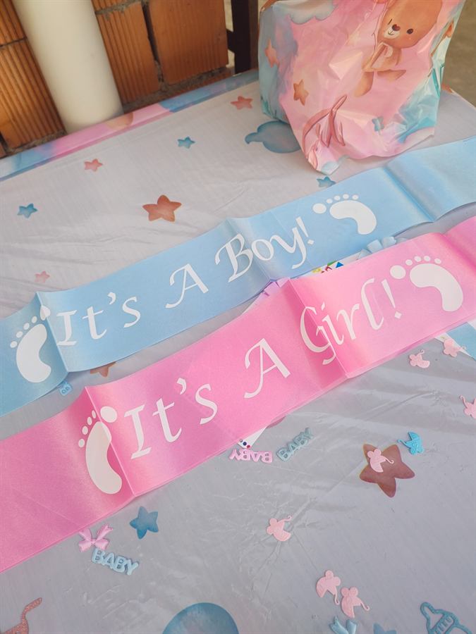 Fasce con le scritte It’s a Boy e It’s a Girl appoggiate sulla tavola decorata