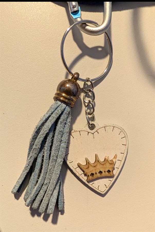 Gadget ricordo con cuore in legno inciso con una coroncina e nappina in tessuto